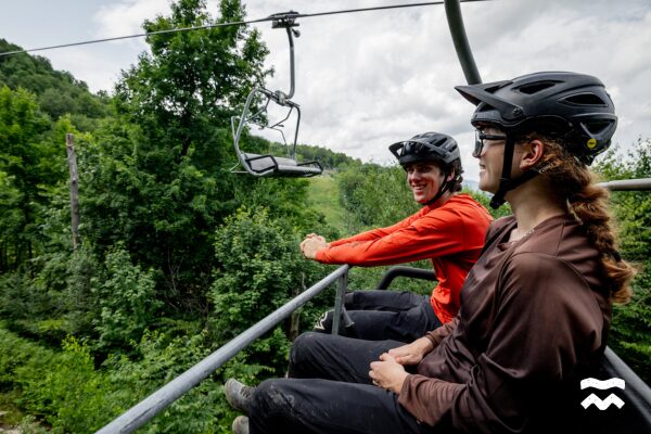 Deux ados souriants dans la remontée mécanique à Bromont, montagne d'expériences