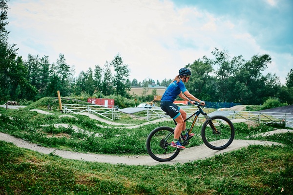 Une femme roule sur une pumptrack extérieure