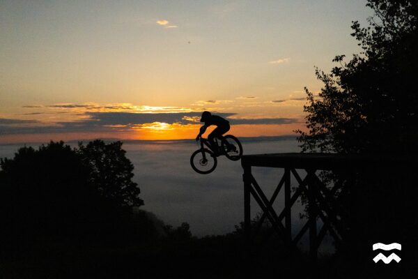 Shawn Querry fait une drop sur fond de soleil couchant au Hatley Bike Park